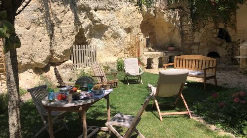 een groep stoelen en een tafel in een tuin bij Le Clos Marie in Fontaine-Milon