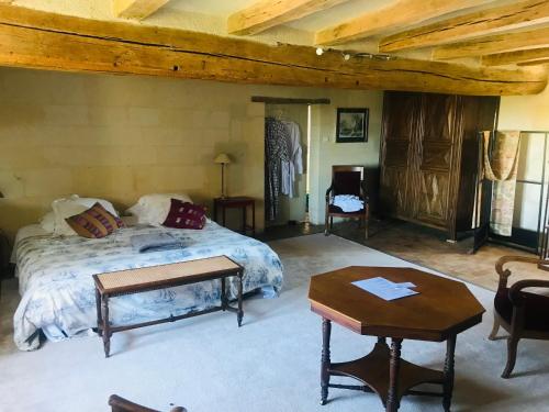 a bedroom with a large bed and a table at Le Clos Marie in Fontaine-Milon