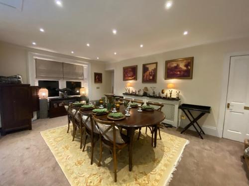 a dining room with a table and chairs and a kitchen at The West Highland Way Hotel Accommodation in Glasgow