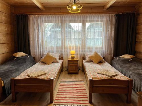 um quarto com 2 camas individuais e uma janela em Jaworowe Izby em Bukowina Tatrzańska