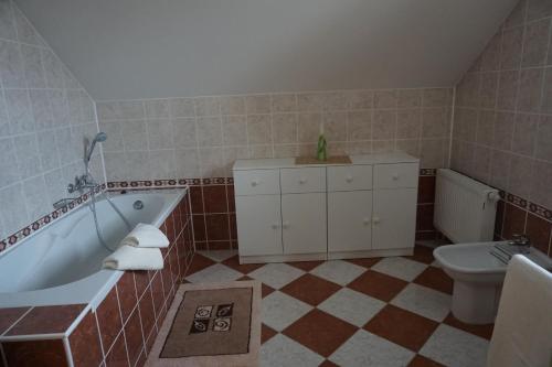 a bathroom with a tub and a toilet at Chalupa u golfu Kořenec in Kořenec
