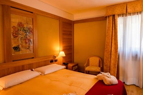 a bedroom with a bed and a window at Grand Hotel Sestriere in Sestriere