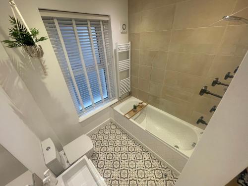 ein Badezimmer mit einer Dusche, einer Badewanne und einem WC in der Unterkunft Seaview flat with balcony, spacious 2 bedroom in Worthing