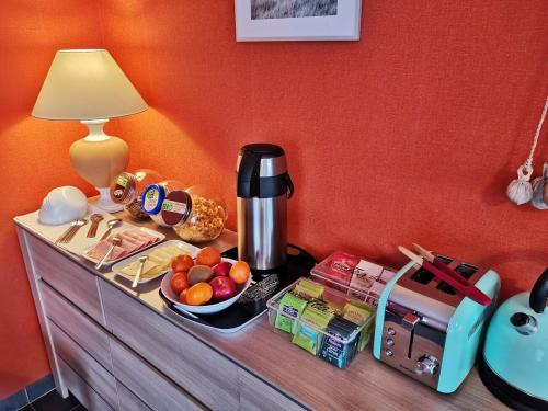 una mesa con cafetera y un bol de fruta en Chambres d'hôtes GIDY, en Gidy