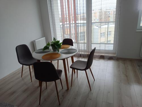 ein Esszimmer mit einem Tisch und 4 Stühlen in der Unterkunft Apartament 41 in Rumia