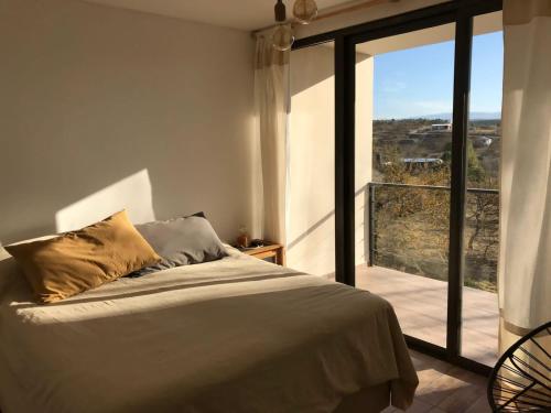 1 dormitorio con cama y ventana grande en Altos del Espinillo - Casa de Montaña in 