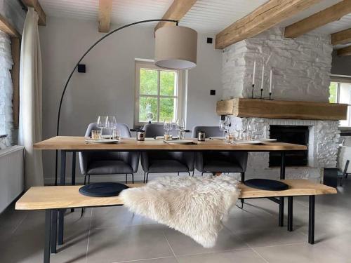 a dining room with a table and chairs with a fireplace at Charmante maison de vacances in Vaux-sur-Sûre