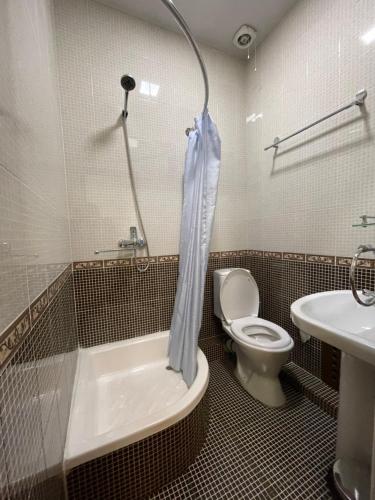 a bathroom with a tub and a toilet and a sink at Mutara Bukhara in Bukhara