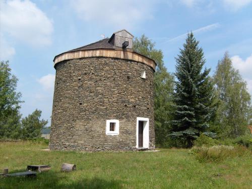 an old brick tower in a field with a tree at Chalupa u golfu Kořenec in Kořenec