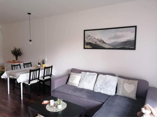 sala de estar con sofá azul y mesa en Apartmán u Tesáka - Říčky v Orlických horách en Říčky