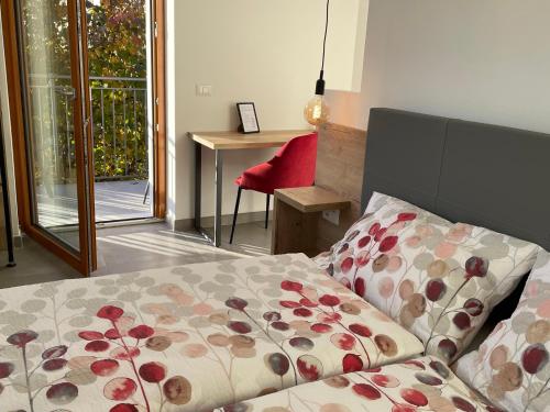 1 dormitorio con cama, silla roja y ventana en B&B NALÙ, en Arco