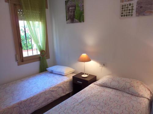 two twin beds in a room with a window at El nispero in Peniscola
