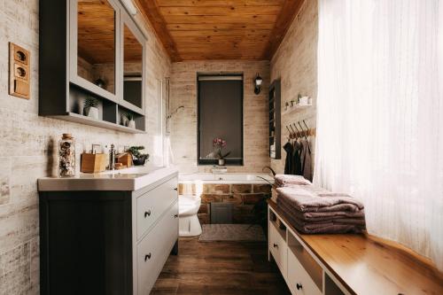 a bathroom with a sink and a toilet and a tub at Lovasberényi Kis Levendulás Sóházikó in Lovasberény