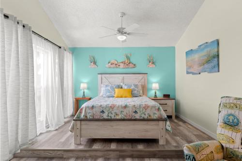 um quarto com uma cama e uma parede azul em Madeira Beach Yacht Club 357H em St Pete Beach