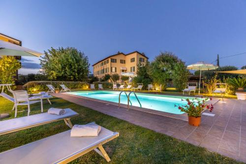 - une piscine avec deux bancs à côté d'une maison dans l'établissement Villa Gabriella, à Lucques