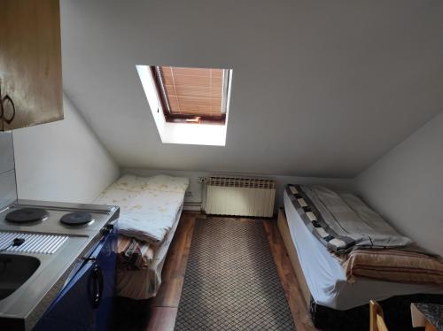 mały pokój z 2 łóżkami i oknem w obiekcie Apartmani Konta w mieście Livno