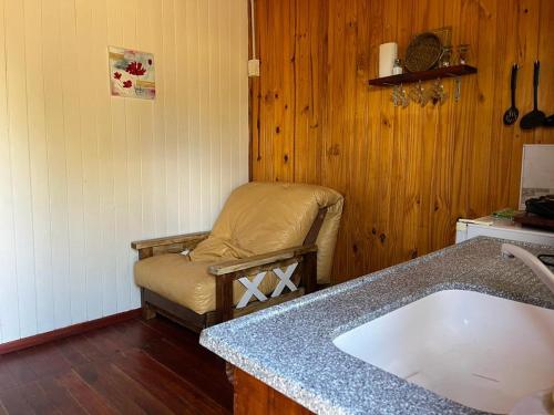 cocina con silla y lavabo en una habitación en La Querencia en San José
