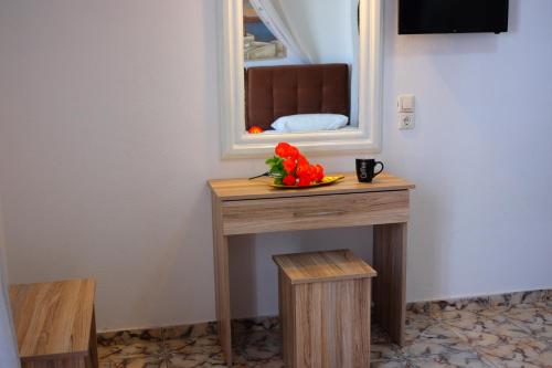 a table with a mirror and a bowl of flowers on it at Sweet Heart Studios in Kamari