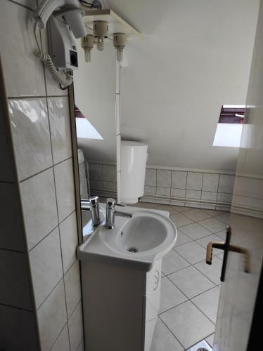 a white sink in a bathroom with a window at Apartmani Konta in Livno