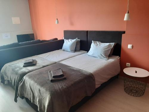 une chambre d'hôtel avec deux lits et un canapé dans l'établissement Quartos Do Seixe - Laranja, à Odeceixe