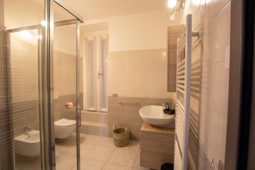 La salle de bains est pourvue d'une douche, d'un lavabo et de toilettes. dans l'établissement APPARTAMENTO PERSEO, à Lezzeno
