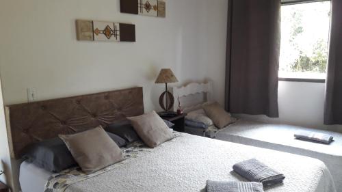 a bedroom with two beds and a window at Chalé das Alamandas in Socorro