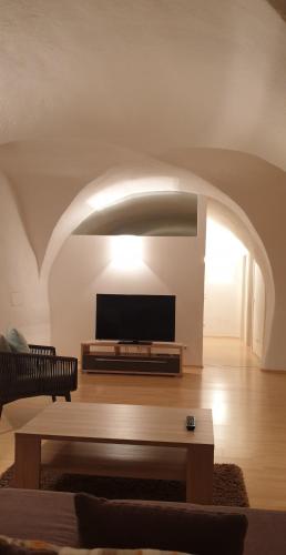 a living room with a tv and a coffee table at Ansitz Strengherrnhof in Caldaro