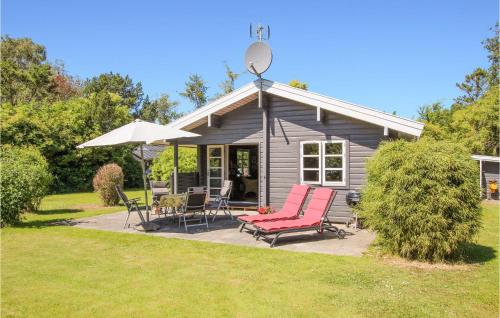 a small house with two chairs and an umbrella at 2 Bedroom Awesome Home In Samsø in Nordby