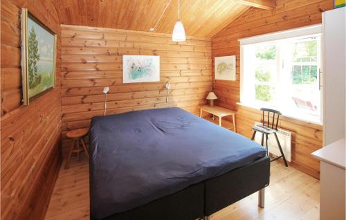 a bedroom with a bed in a wooden room at 2 Bedroom Awesome Home In Samsø in Nordby