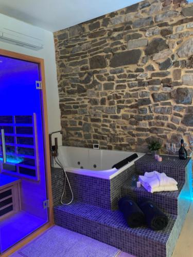 a room with a bath tub with a stone wall at Namur à Mur in Namur