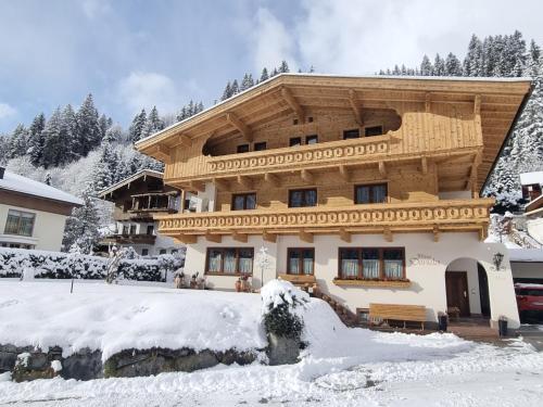 ein großes Holzhaus im Schnee in der Unterkunft Haus Daniela in Gerlos