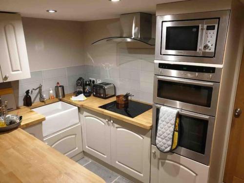 uma cozinha com uma placa de fogão e um micro-ondas em Luxury Barn Conversion at Rudding em Harrogate