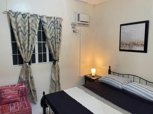 a bedroom with a bed and a window at Townhouse Apartment near SM City Lucena in Lucena