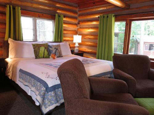 um quarto com uma cama num chalé de madeira em Tall Pines Inn em Eureka Springs