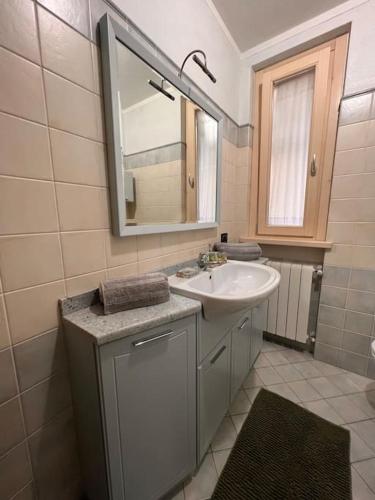 a bathroom with a sink and a mirror at Csendes és nyugodt hely medencével. in Parzanica
