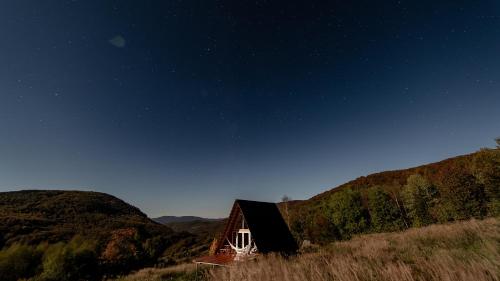 a small house in the middle of a hill at night at To Lem Ande in Lumshory