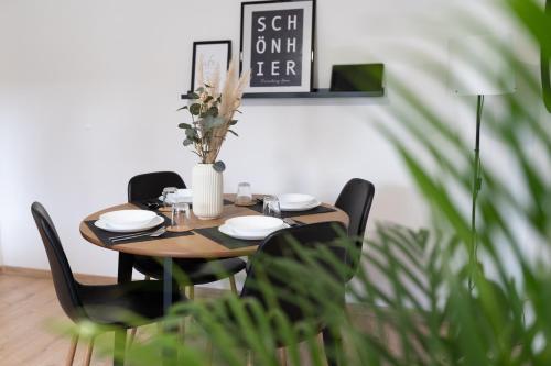 a wooden table with chairs and a vase with flowers at Modern 3Room Apartment Free Wifi Netflix and free Parking in Hamm