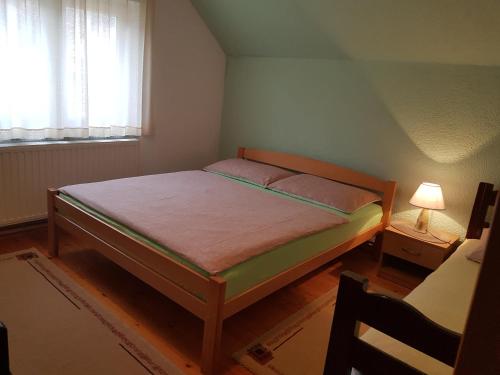 a small bedroom with a bed and a window at Apartman Herceg in Kupres