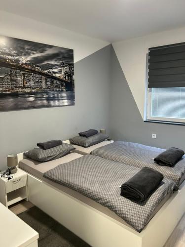 2 camas en un dormitorio con una foto en la pared en Apartmani "Stari Grad - Samobor", en Samobor