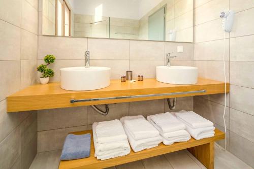 Baño con 2 lavabos y toallas en un estante en Villa Rodakinia, en Ambelókipoi