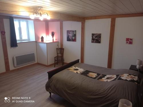 um quarto com uma cama, uma cozinha e uma janela em Appartement spacieux au coeur de la nature em Fougerolles