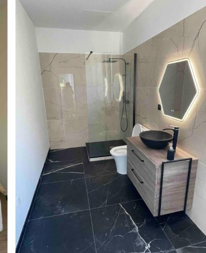 une salle de bain avec un lavabo, une douche et des toilettes dans l'établissement Chambre avec balcon à louer, à Bains de Guitera