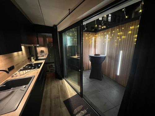 uma cozinha com um lavatório e uma parede de vidro em Fabuleusement romantique em Verviers