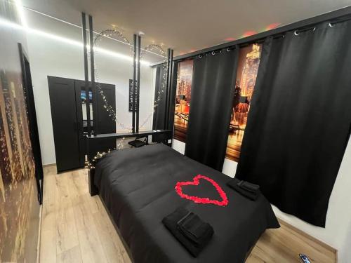 um quarto com uma cama preta com uma boca vermelha em Fabuleusement romantique em Verviers