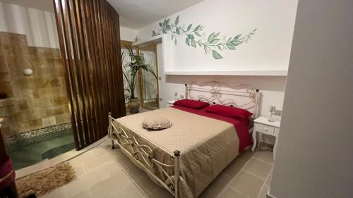 a bedroom with a bed with red pillows and a bath tub at Lemon Suite-Luxury in Cellino San Marco