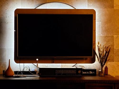 einen Flachbild-TV auf einem Schreibtisch in der Unterkunft Chez Claude appartement cozy climatisé pour 4 personnes tout confort in Ath