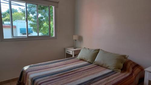 een slaapkamer met een bed en een raam bij Depto calle 18 - soleado y con balcon in La Plata