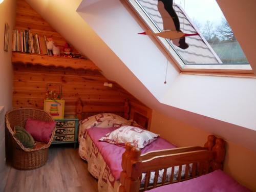sypialnia z łóżkiem i oknem na poddaszu w obiekcie Gîte du Durrenbach w mieście Lautenbach