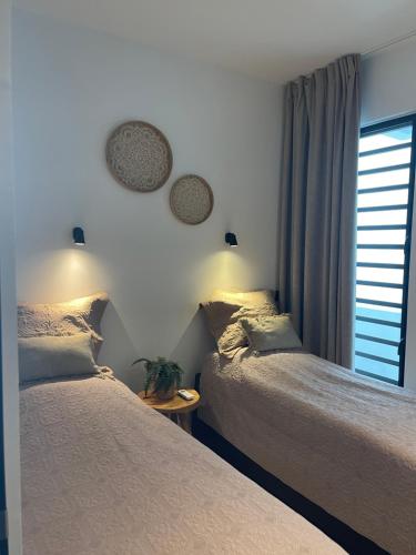 a bedroom with two beds next to a window at The Reef 28 Blue Bay Curacao in Dorp Sint Michiel