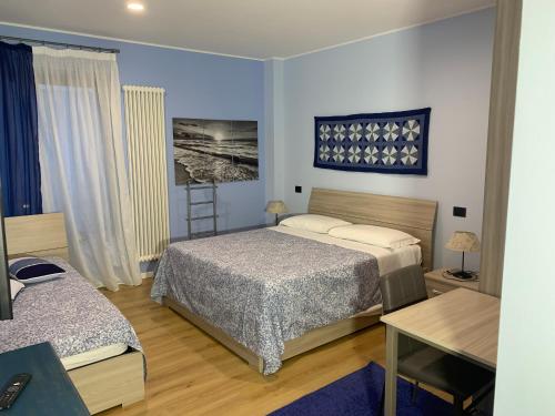1 Schlafzimmer mit 2 Betten, einem Tisch und einem Schreibtisch in der Unterkunft Bed & Breakfast Indi Thelar in Villa Guardia